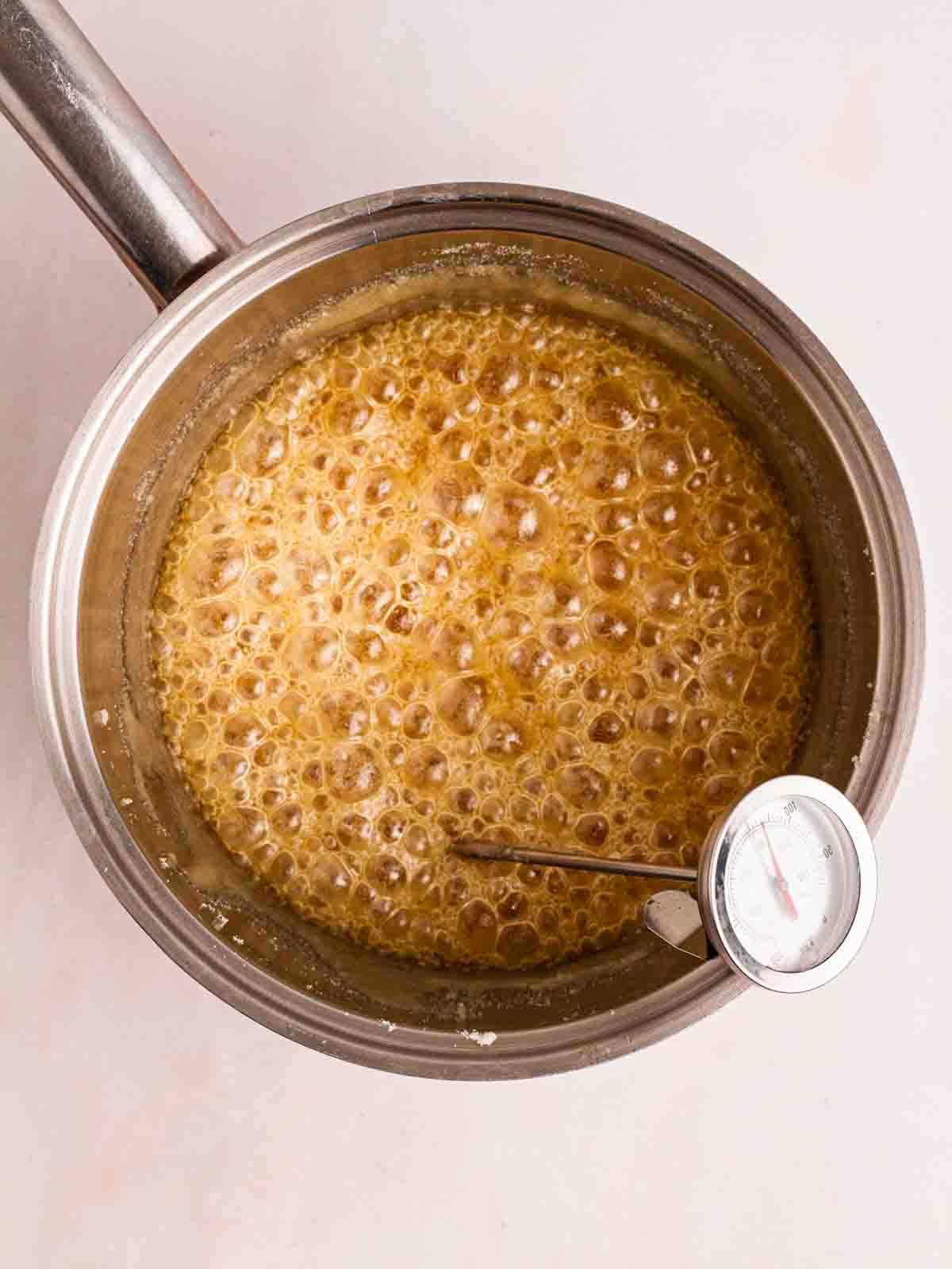 Come fare il nido d'ape 6 Un termometro in una pentola di honeycomb che bolle per il passaggio 2 del processo della ricetta.