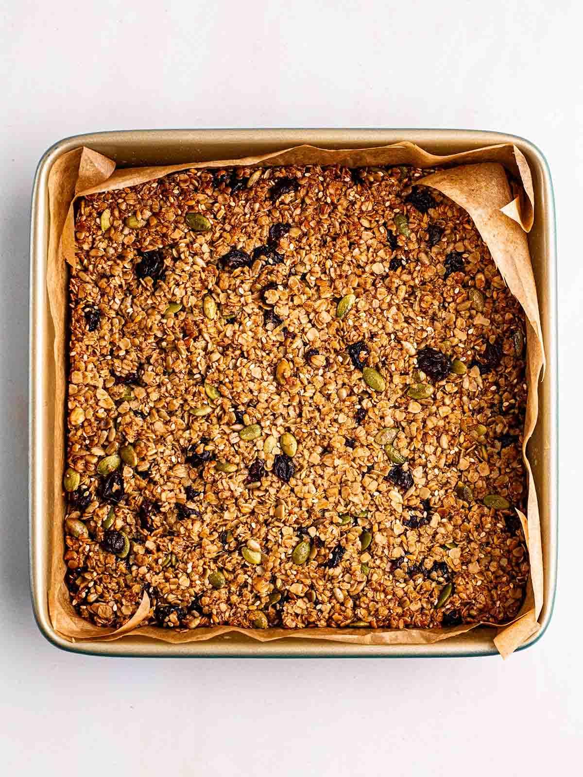 Barrette di Granola {Ricetta Facile!} 6 Una lastra di avena, semi e frutta, cotta in una teglia per il passaggio 3 nel processo delle barrette di granola.