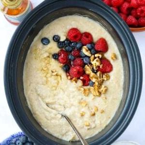 Porridge a cottura lenta 6 Una pentola slow cooker riempita di Porridge cotto, condita con frutti di bosco e noci.