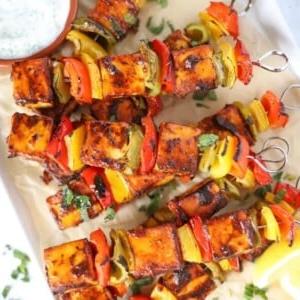 Facile Paneer Tikka {Per Griglia, Forno o Barbecue} 6 Un vassoio con spiedini di Paneer Tikka cotti e una ciotola di raita a lato.