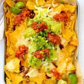 Piano Pasti 10 {Pasti da 10 Minuti} 6 Una teglia da forno riempita con nachos ricchi di verdure colorate, conditi con salsa fresca e guacamole cremoso.