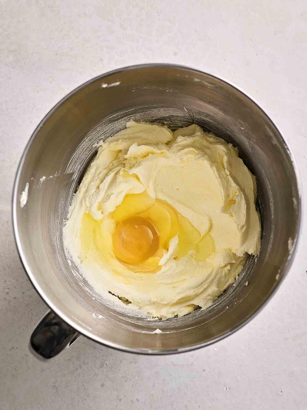 Torta Victoria Classica 6 Un impasto per torta in una ciotola con un uovo sopra, pronto per essere miscelato, per il passo 2 della ricetta per Victoria Sponge.