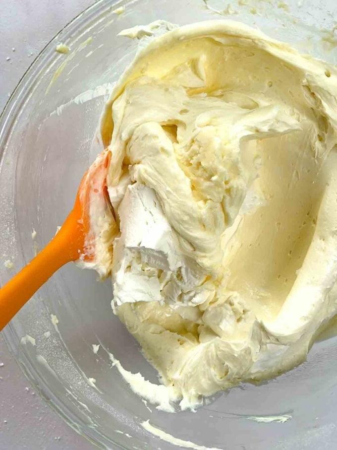 Glassa al Formaggio Cremoso {per Torte e Dolci al Forno} 6 Gli ingredienti per la glassa al formaggio cremoso tutti miscelati in una ciotola di vetro per formare un composto.