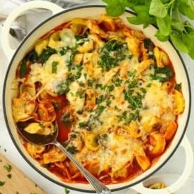 Una pentola piena di tortellini al forno con spinaci e ricotta freschi - un semplice pasto da 10 minuti.
