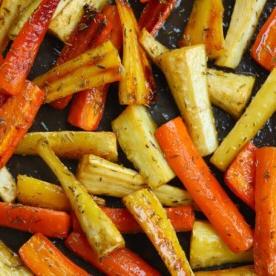 Menù di San Valentino o delle Amiche 7 Primo piano di carote e pastinache arrosto al miele su una teglia, appena sfornate.