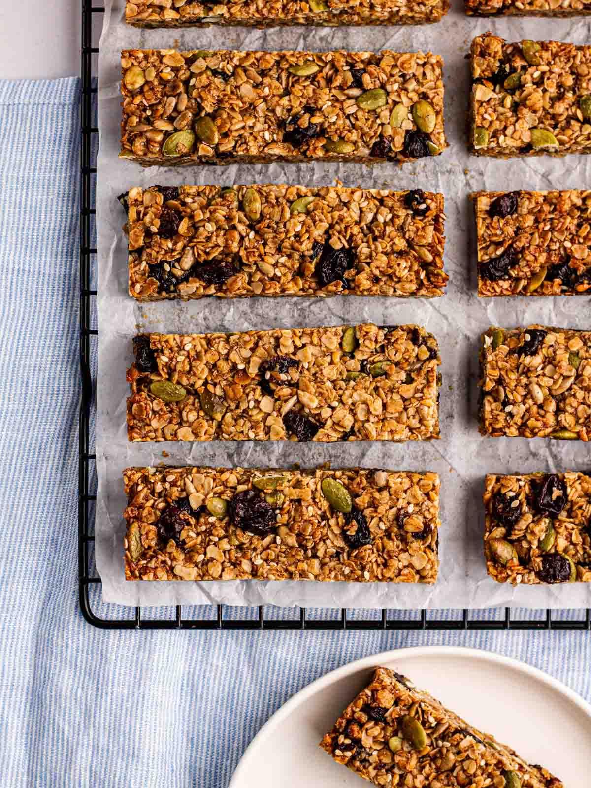 Barrette di Granola {Ricetta Facile!} 7 Fila di barrette di granola fatte in casa su una griglia dopo la cottura.