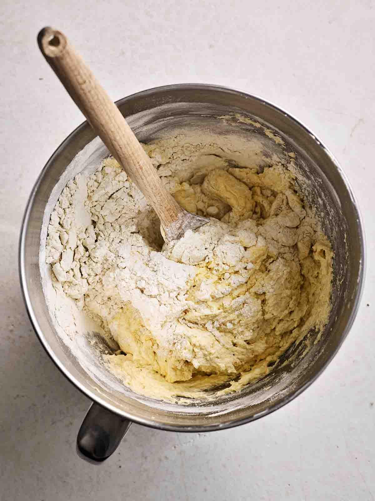 Torta Victoria Classica 7 Una ciotola con farina mescolata nell'impasto con un cucchiaio di legno, per il passo 3 della ricetta per Victoria Sponge.