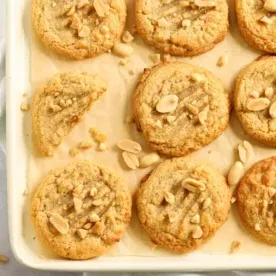 Domenica di Preparazione: Pasti per la Settimana 3 7 Una teglia di biscotti al burro d'arachidi appena sfornati su una teglia foderata con arachidi tritate spolverate sopra.