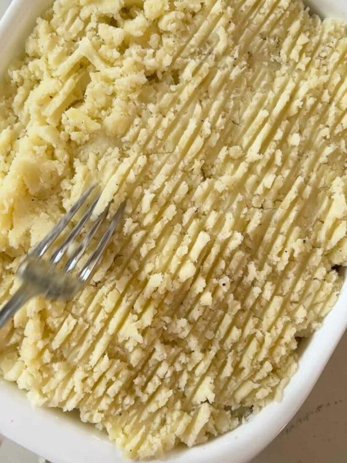 Il Pasticcio Vegetariano Definitivo 8 I tocchi finali alla ricetta del Pasticcio Vegetariano. Fare dei solchi nella purea di patate con una forchetta per renderla croccante in superficie.