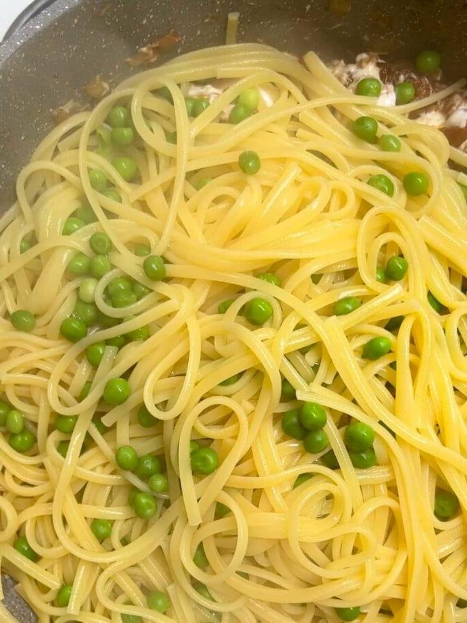 Spaghetti e piselli in una padella aggiunti a cipolle e pancetta per la ricetta della Pasta con Pancetta. Passaggio 4. 