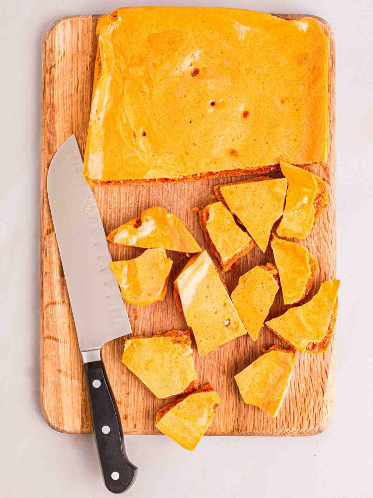 Come fare il nido d'ape 9 Un tagliere di legno con honeycomb appena fatto in casa, con metà tagliata a pezzi con un coltello.