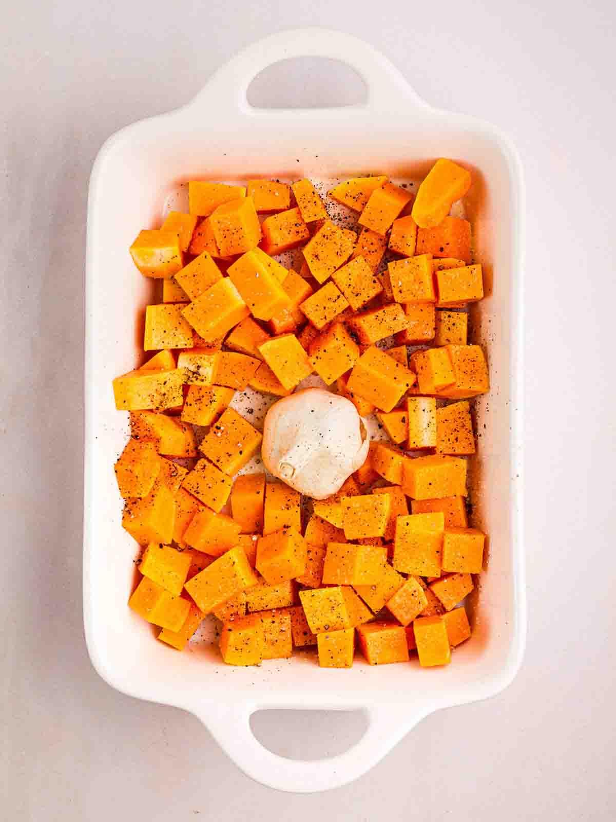 **Risotto di Zucca {Al Forno o Tradizionale}** 9 Una teglia da forno con cubetti di zucca butternut e una testa d'aglio al centro.