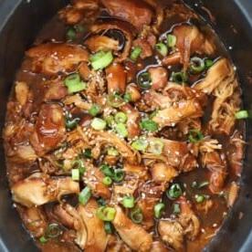 **Sacchetti Pronti per la Cottura Lenta {Pasti da Congelare e Pronti all'Uso}** 9 Una pentola a cottura lenta piena di una deliziosa salsa al pollo e aglio e miele, con cipollotti cosparsi sopra.