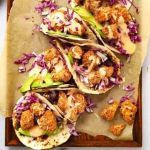 Tacos di Cavolfiore Croccante (con Maionese al Peperoncino Dolce) 9 Delicious crispy Cauliflower Tacos on a tray, ready to be eaten.