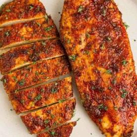 Domenica: Preparazione Pasti per la Settimana 5 10 Due petti di pollo con panatura su una superficie bianca dopo essere stati cotti nella friggitrice ad aria.
