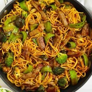 Manzo Glassato e Noodles {Monopadella} 10 Una padella rotonda piena di noodles, bistecca, verdure verdi e salsa per la ricetta Manzo Appiccicoso e Noodles.