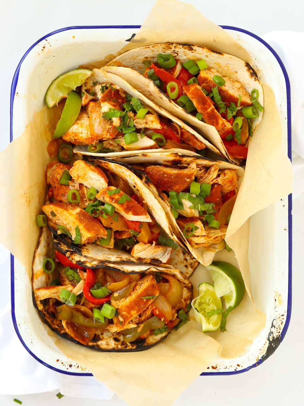 Ricetta per fajitas di pollo in slow cooker, servite in tortillas.
