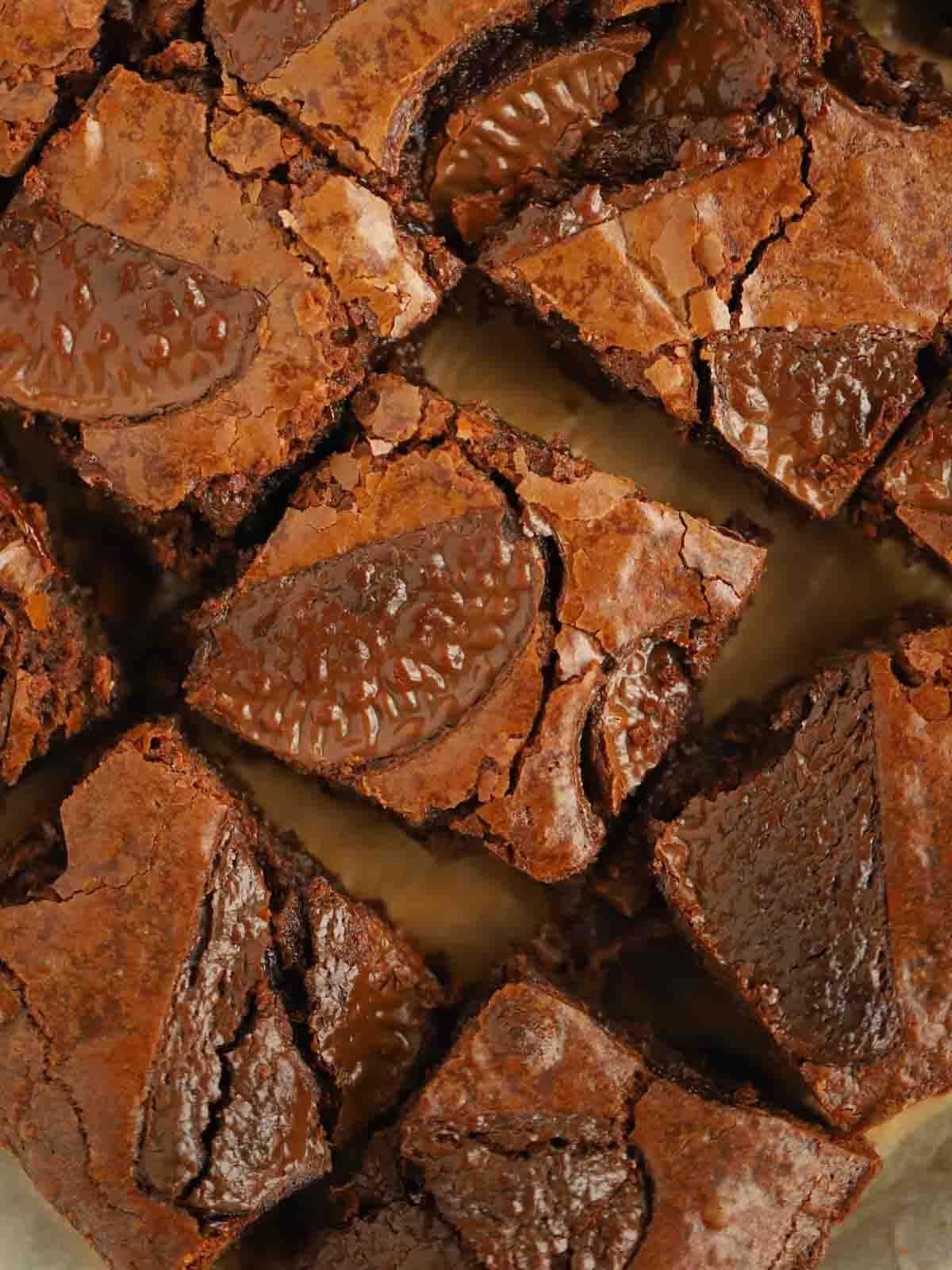 Brownies al Cioccolato e Arancia {Facile e Delizioso!} 2 Primo piano di brownies al cioccolato e arancia su un tagliere, con la loro consistenza densa e invitante.