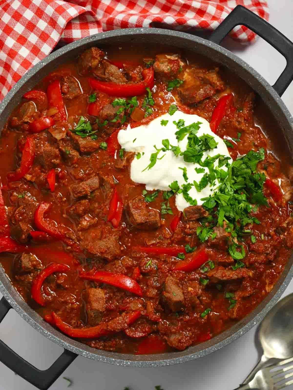 Gulasch di Manzo 2 Una grande pentola colma di goulash di manzo preparato in slow cooker, pronto per essere servito.
