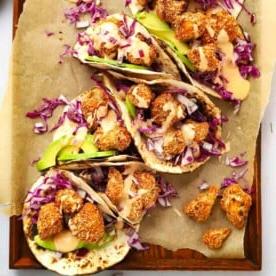 Piano Pasti 20 3 Tacos di Cavolfiore croccanti con maionese al peperoncino dolce su un vassoio, pronti per essere gustati.