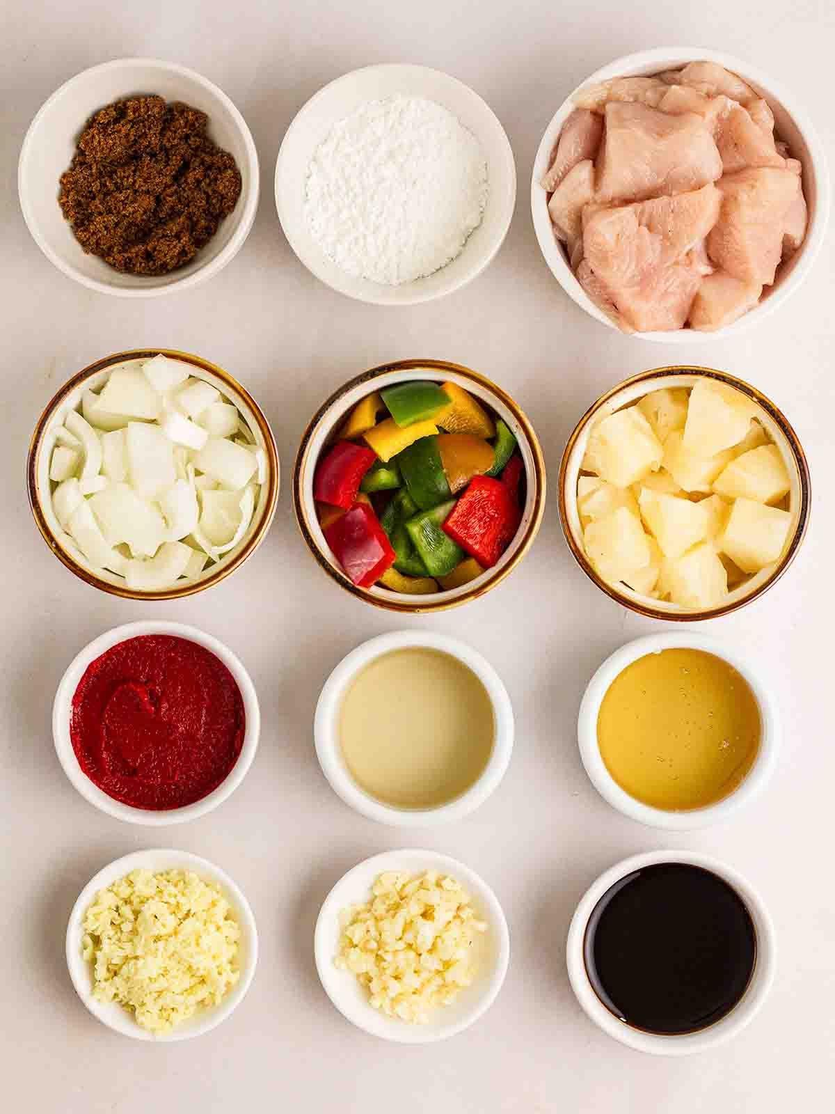 Pollo in Agrodolce {Ricetta Facile!} 3 Piccole ciotole di ingredienti per preparare il Pollo in Agrodolce disposte su un bancone bianco.
