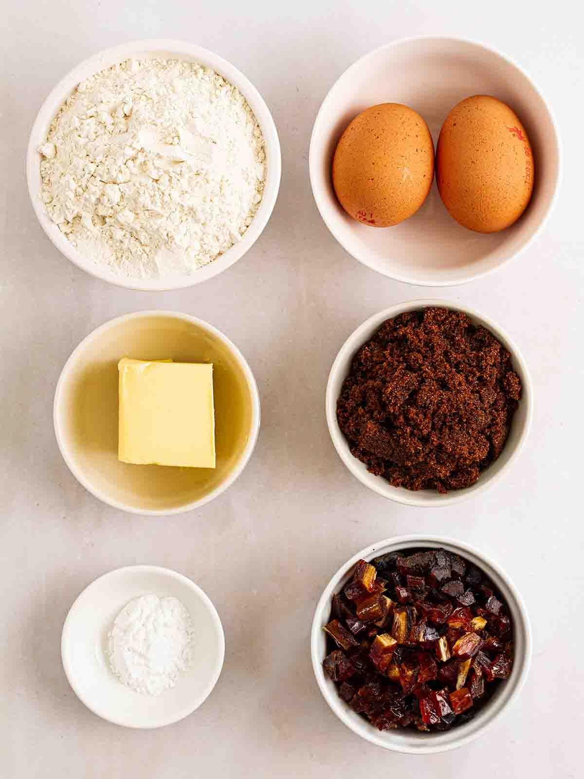 Pudding al Caramello Appiccicoso in Slow Cooker 4 Gli ingredienti per preparare il budino al toffee appiccicoso nel slow cooker disposti su un piano di lavoro bianco.