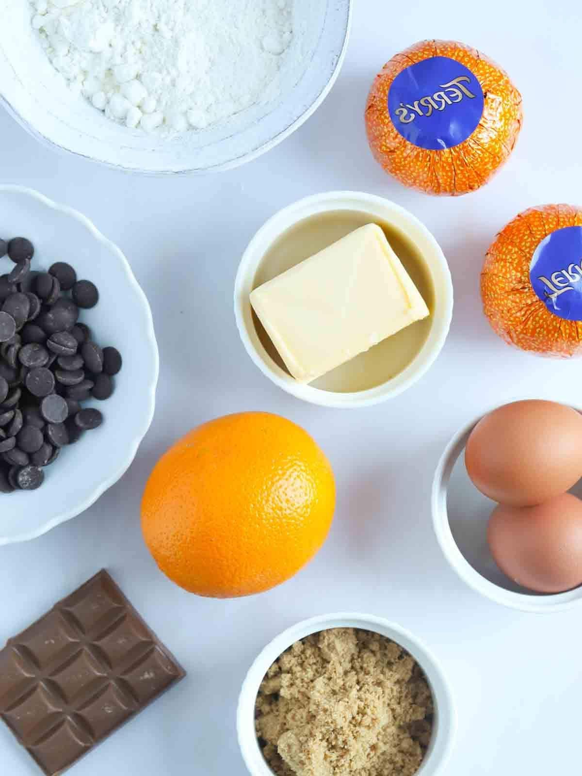 Brownies al Cioccolato e Arancia {Facile e Delizioso!} 4 Gli ingredienti per i Brownies al Cioccolato e Arancia disposti su un piano di lavoro, pronti per essere utilizzati.