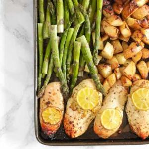 **Teglia di Pollo al Limone con Asparagi** 4 Una teglia con pollo al limone, asparagi e patate al forno, con limone sopra, pronto per essere servito.