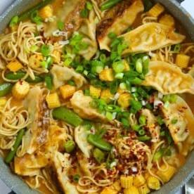 Pasti da 15 minuti {Settimana 2} 4 Una pentola piena di Zuppa di Gyoza corposa, con noodles, ravioli e verdure in una salsa thailandese rossa.