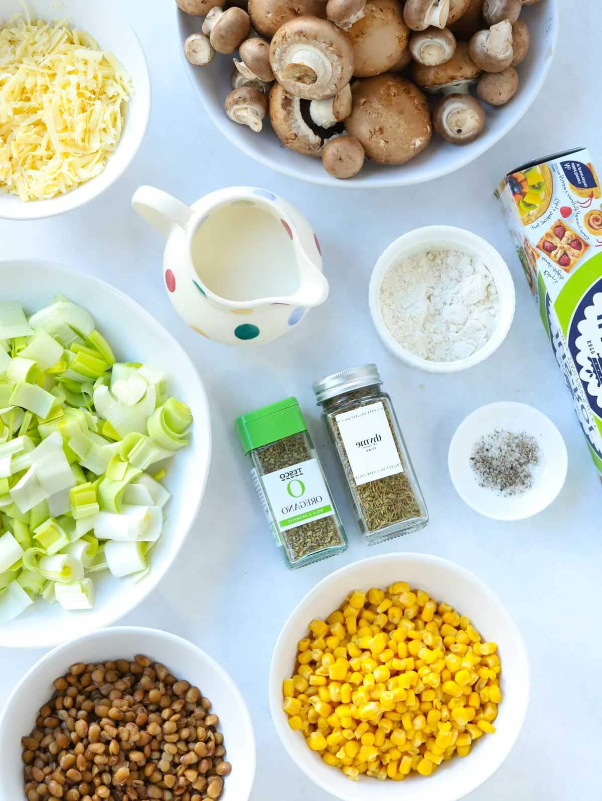 Torta Salata Vegetariana al Formaggio {con Pasta Sfoglia} 4 Gli ingredienti per una torta salata vegetariana al formaggio disposti su un piano di lavoro.