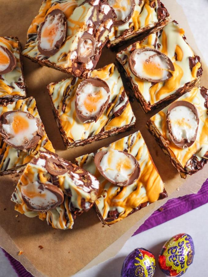 Ricetta Rocky Road al Creme Egg 4 Pezzi di Rocky Road con Creme Egg tagliati su un tagliere.