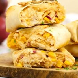 Pasti da 15 minuti {Settimana 2} 5 Una pila di wrap di pollo cotto affettato con formaggio e mais dolce, pronti da servire.