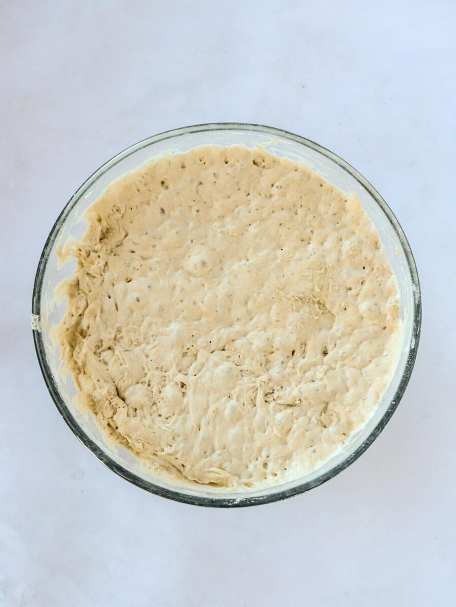 Pane Senza Impasto {La Ricetta Notturna Più Semplice di Sempre} 6 Miscela di impasto per il pane in una ciotola di vetro circolare per il passaggio 2 del processo della ricetta del Pane Senza Impasto.