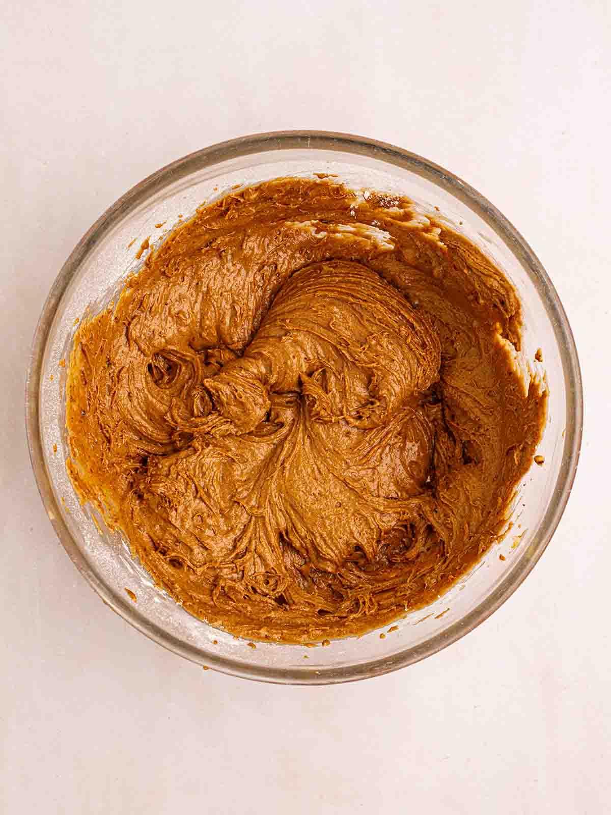 Pudding al Caramello Appiccicoso in Slow Cooker 6 Una ciotola di vetro con un impasto marrone per il passaggio 2 della ricetta del Budino al Toffee Appiccicoso al Slow Cooker.