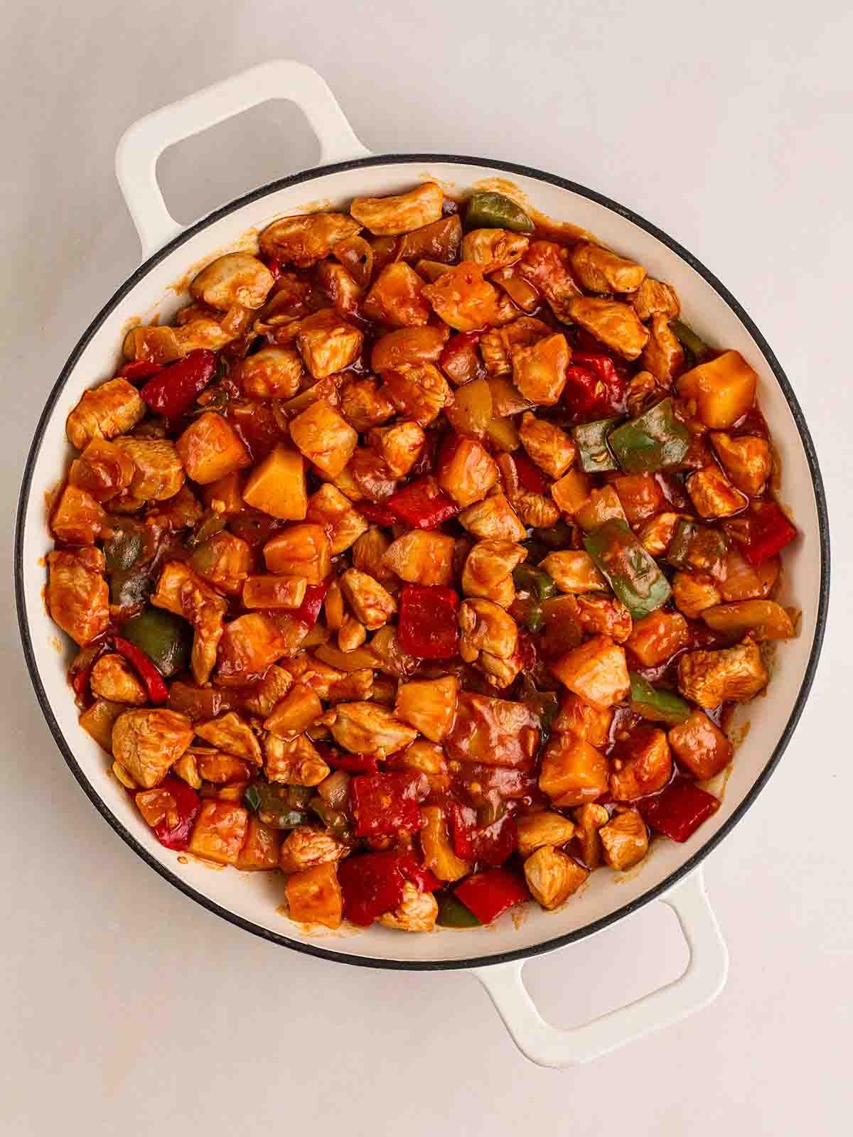 Pollo in Agrodolce {Ricetta Facile!} 7 Una grande padella bianca piena di Pollo in Agrodolce cotto.