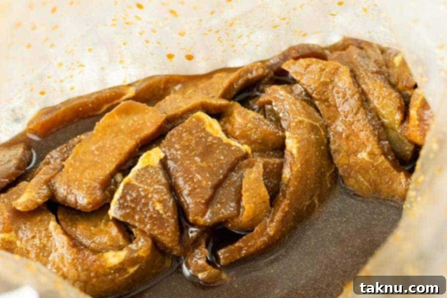 Beef strips marinating in a resealable bag, fully coated with teriyaki sauce.