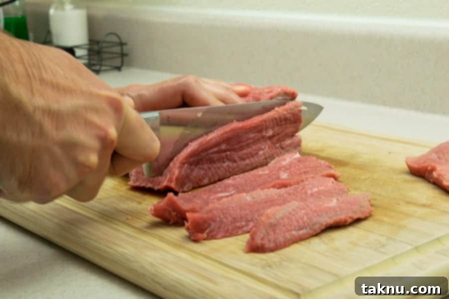Slicing meat for jerky on cutting board