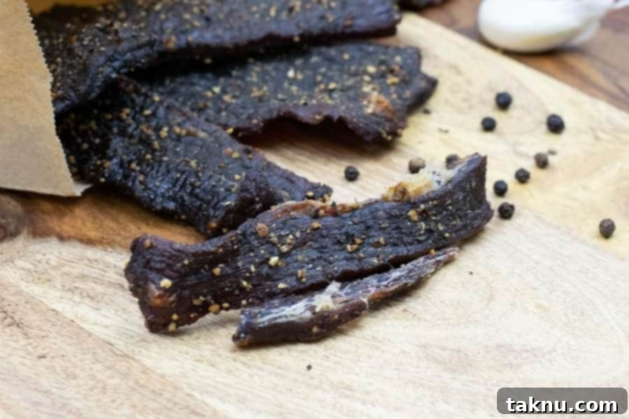 Fibers of meat showing beef jerky is finished on cutting board