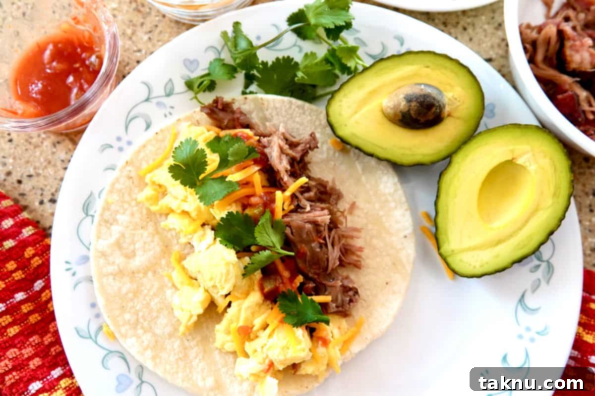 scrambled eggs, pulled pork taco topped with salsa, cheddar cheese and cilantro. Halved avocado