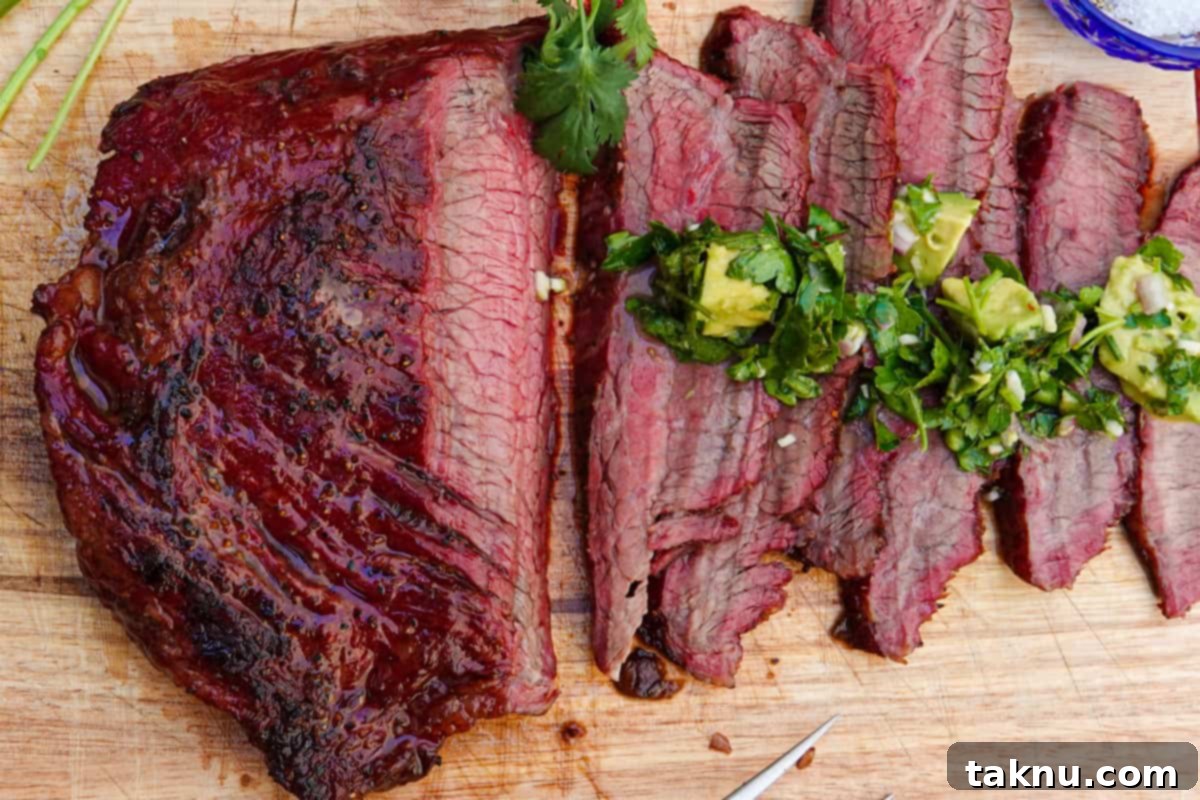 Flank steak sliced on cutting board with chimichurri sauce
