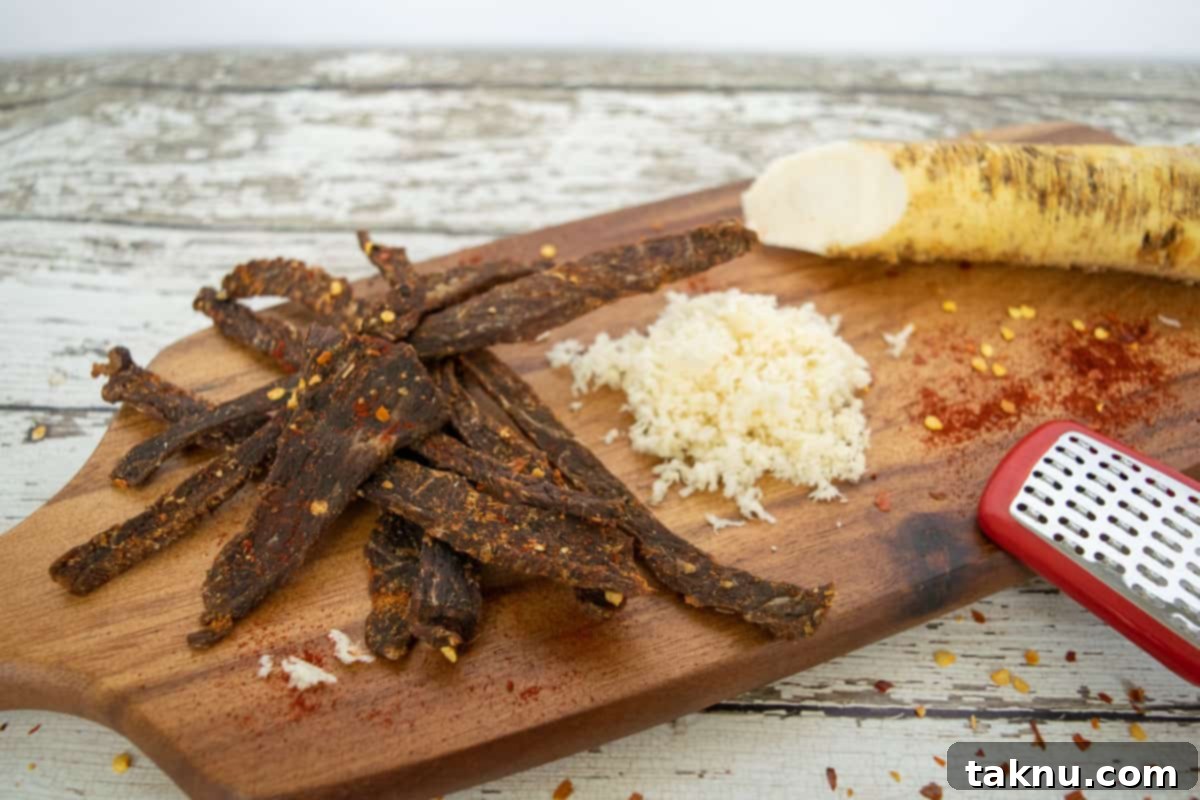 Cajun Beef Jerky on a cutting board with grated horseradish