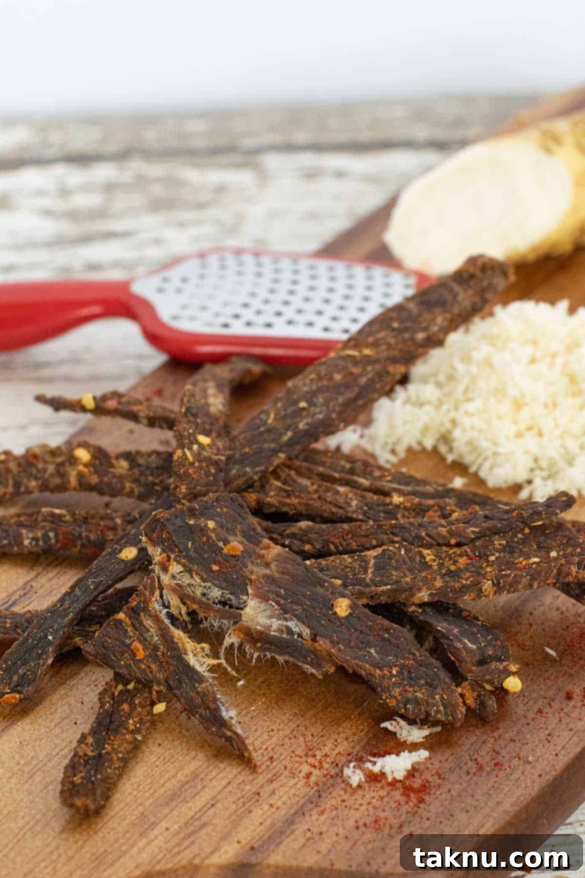 Plate of homemade Cajun beef jerky strips, garnished with fresh herbs, ready for serving