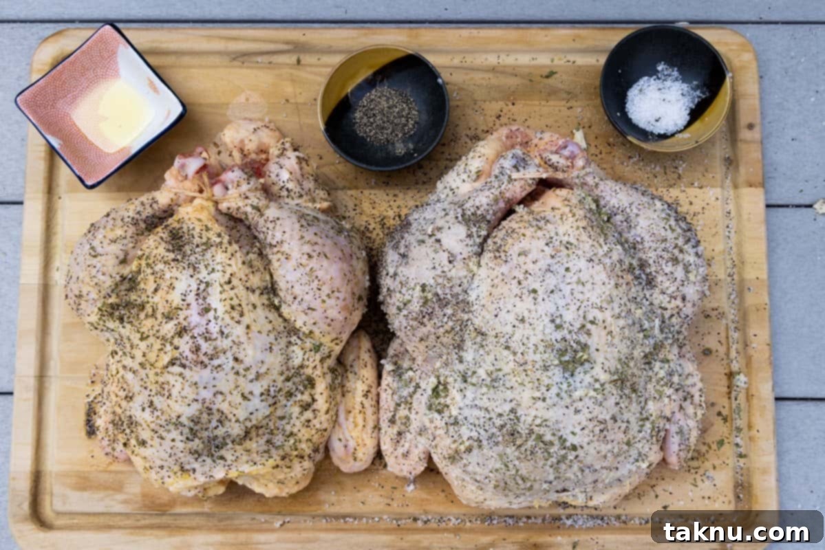 Chickens on cutting board seasoned with salt, pepper, garlic, parsley and ready to be cooked