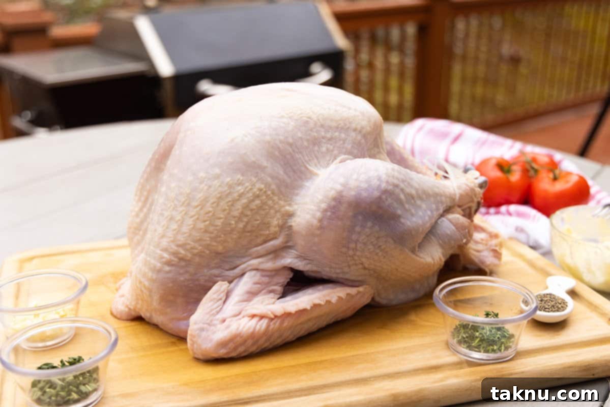 Crispy Skinned Smoked Turkey Masterpiece 4 A brined and dried turkey resting on a cutting board, with small dishes of seasoning ingredients arranged around it.