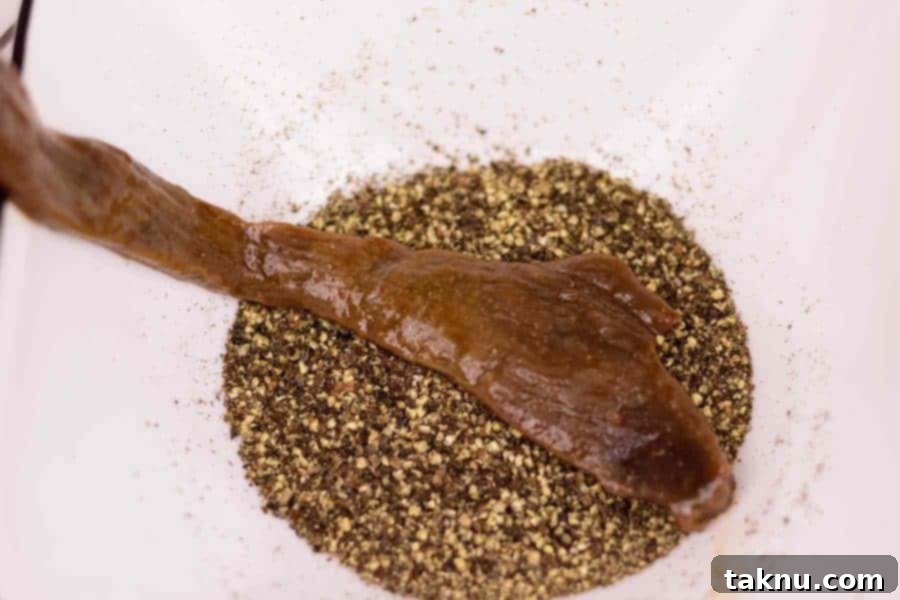 Sliced deer in bowl of black pepper