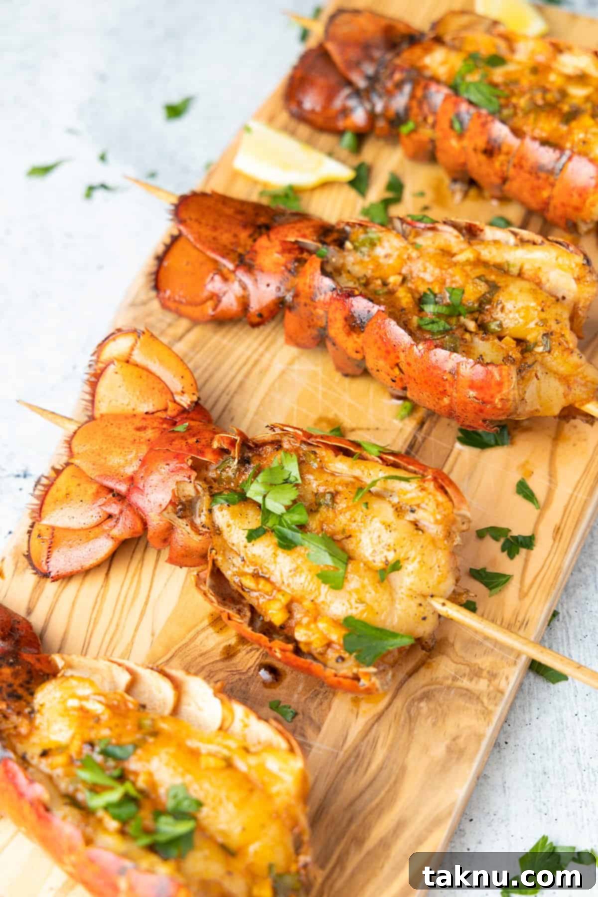 Lobster tails on cutting board seasoned with parsley