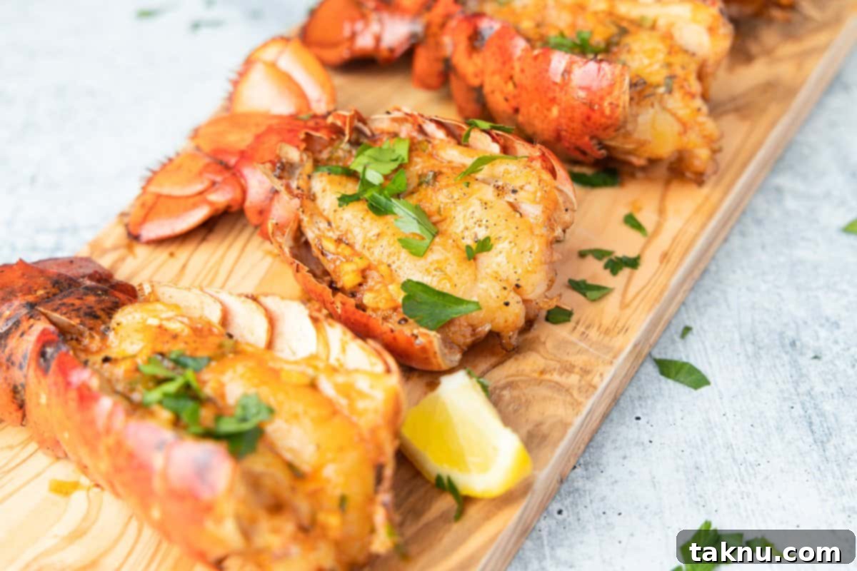 Lobster tails on cutting board with garnish and lemons