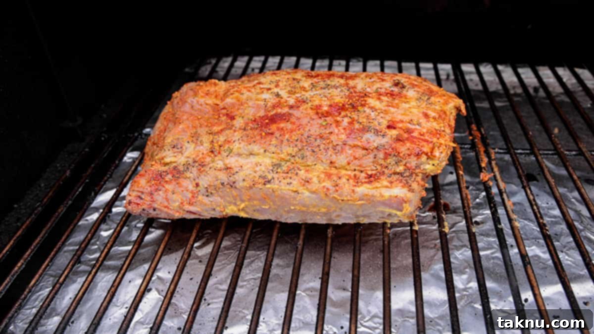 Slow-Smoked Corned Beef 7 Seasoned corned beef brisket with a temperature probe inserted, sitting on a smoker grate.