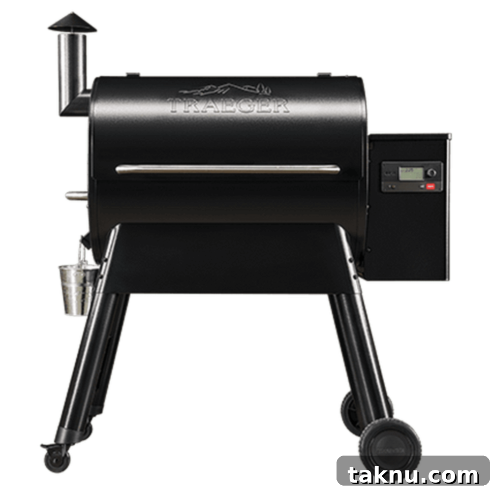 Perfect Traeger Pork Chops 8 A high-angle shot of a modern, sleek black pellet grill, likely a Traeger, with its control panel visible and ready for use.