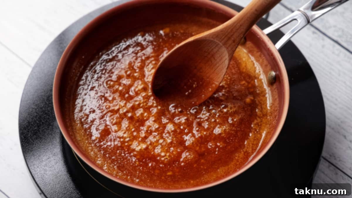 Sweet Apricot Smoked Ham 4 Apricot glaze simmering in a saucepan with a wooden spoon, heating gently on a hot plate.